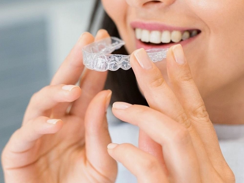Illustrative close-up of a person fitting a clear dental aligner