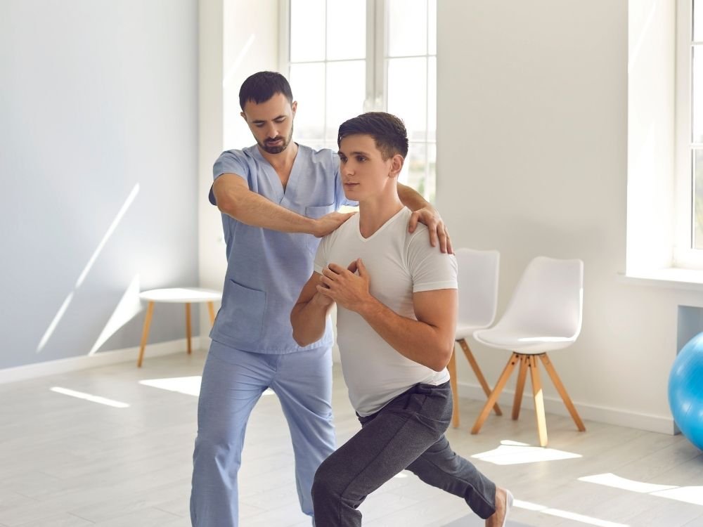 Illustrative physiotherapist assisting a patient with a seated rehabilitation exercise